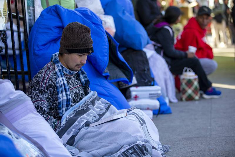 A migrant reads the Bible while camping outside the Sacred Heart Church. AP