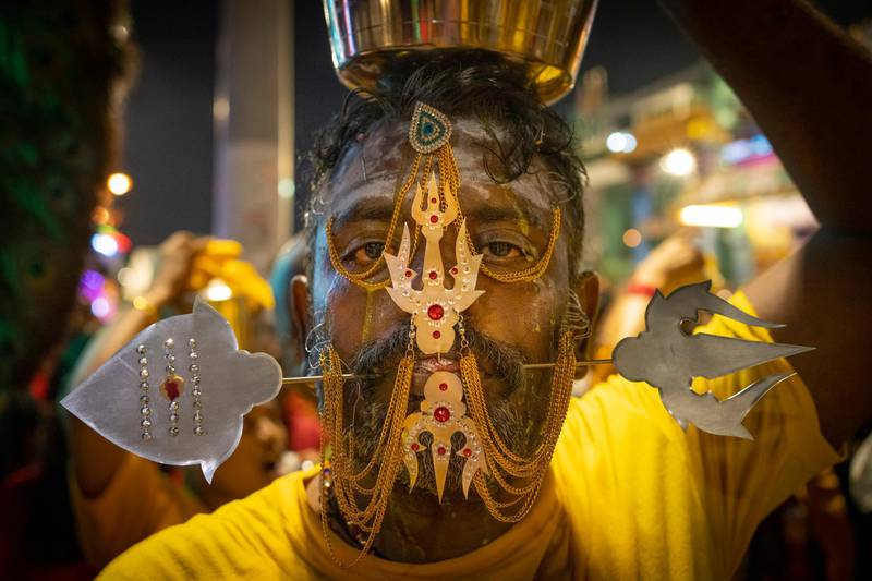 A Hindu devotees carries a milk pot on his head with his cheek pierced with a metal rod in a procession during the Thaipusam festival at Batu Caves, outskirts of Kuala Lumpur. AP Photo