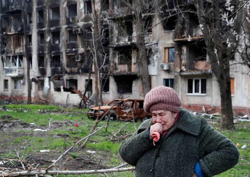 Tamara, 71, cries in front of a destroyed apartment building in Mariupol. Reuters