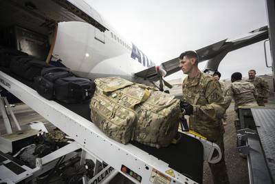 A soldier loads the cargo hold of a chartered Boeing 747 airplane with duffle bags belonging to US soldiers, during their deployment to Europe, at Hunter Army Airfield in Savannah, Georgia. AP