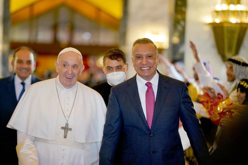 Pope Francis and Iraq's Prime Minister Mustafa Al Kadhimi react after the pontiff's arrival at Baghdad airport in March, 2021. Handout from the office of the Prime Minister of Iraq