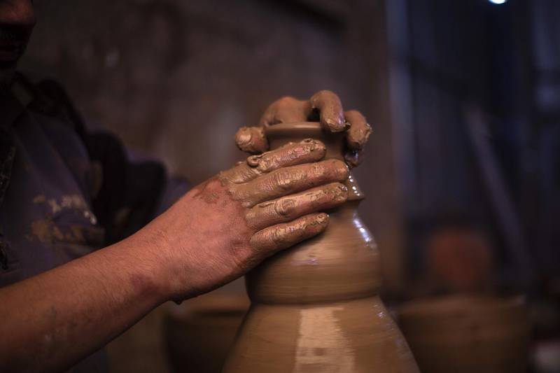 Palestinian craftsman Sid Atallah shapes a pot on a potter's wheel at the family workshop in the central Gaza Strip. AFP