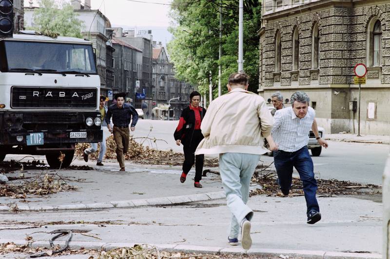 Bosnians run for shelter across a street to avoid shelling from Serbs, in the Bosnian capital Sarajevo, on July 12, 1992. Pascal Guyot/AFP 