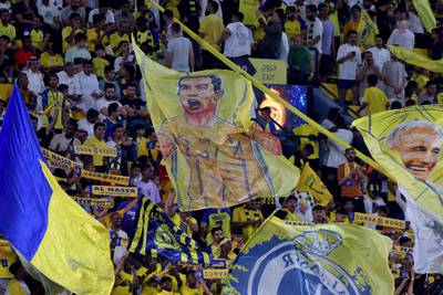 Al Nassr fans wave a banner bearing the image of Cristiano Ronaldo during the match between Al Nassr and Al Shabab. AFP