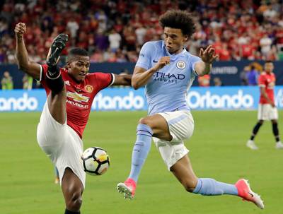 Manchester United's Luis Antonio Valencia, left, tries to block a drive by Manchester City's Leroy Sane, right. David J. Phillip / AP Photo