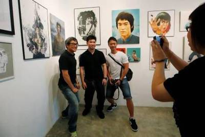 Fans of the late Hong Kong kung fu star Bruce Lee pose at a gallery ahead of the 40th anniversary of Lee’s death.