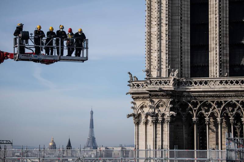 Workers on a crane look at the Notre-Dame cathedral site on November 24, 2020 in Paris.  AFP