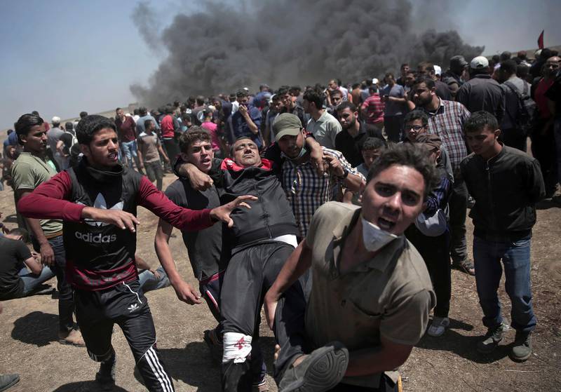 Palestinian protesters carry an injured man who was shot by Israeli troops during a deadly protest at the Gaza Strip's border with Israel, east of Khan Younis, Gaza Strip, Monday, May 14, 2018. Thousands of Palestinians are protesting near Gaza's border with Israel, as Israel celebrates the inauguration of a new U.S. Embassy in contested Jerusalem. (AP Photo/Adel Hana)
