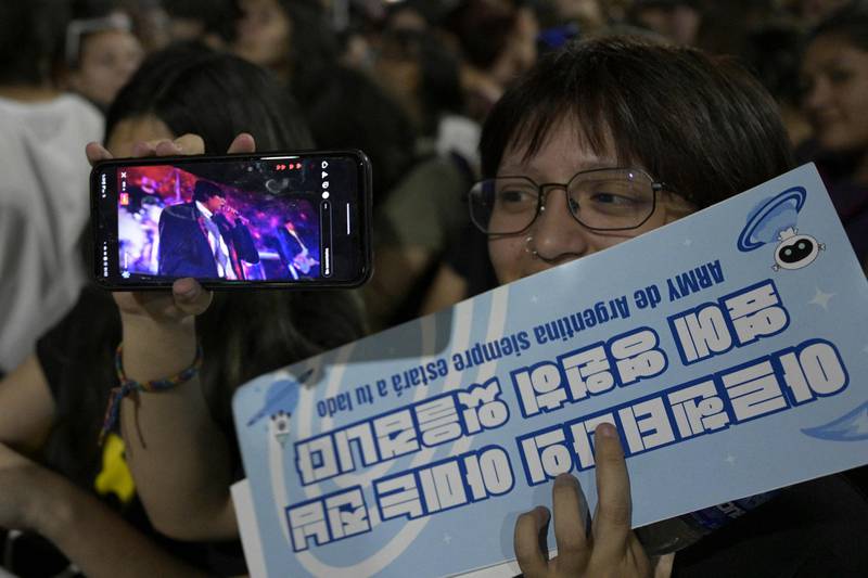 A fan holds up a sign in Korean for BTS member Jin.