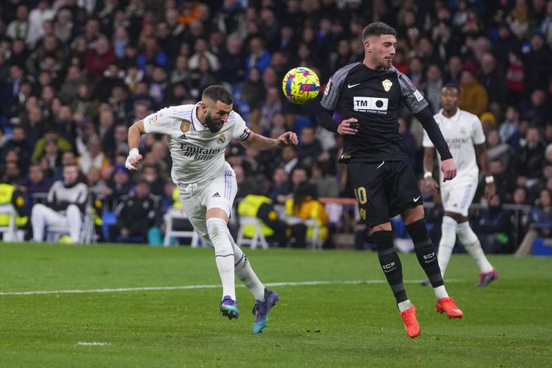 Real Madrid's Karim Benzema, left, heads the ball past Elche's Jose Angel Carmona during Spanish La Liga match at the Santiago Bernabeu in Madrid, Spain, Wednesday, February  15, 2023. Benzema scored twice in a 4-0 win for Real. AP Photo 