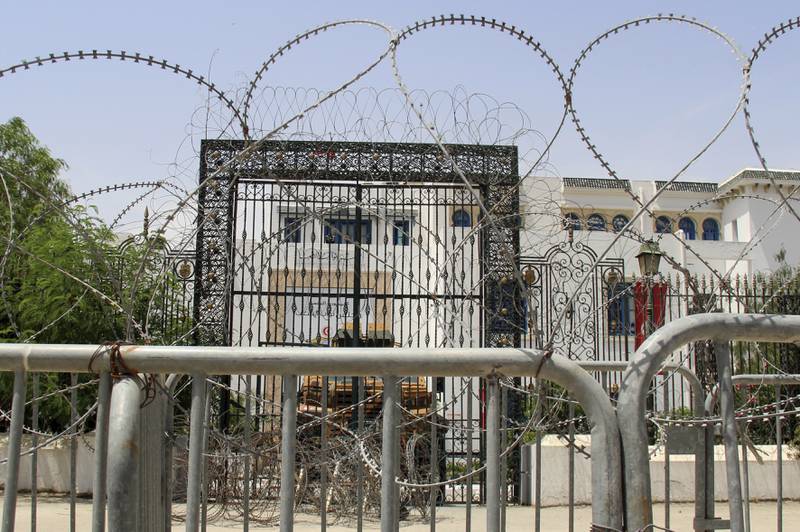 Barbed wire and a military armoured personnel carrier block a side entrance of the Tunisian parliament in Tunis. AP
