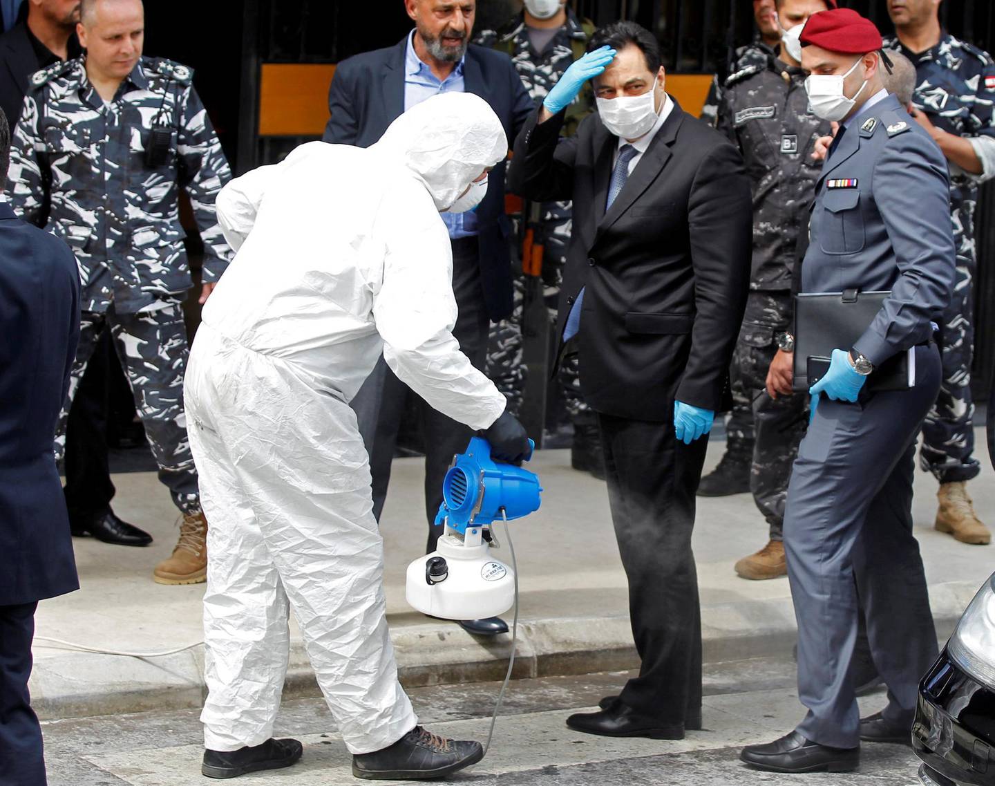 FILE PHOTO: Lebanese Prime Minister Hassan Diab is sprayed with disinfectant as he arrives to attend a legislative session in a theatre hall to allow social distancing amid spread of the coronavirus disease (COVID-19), in the UNESCO Palace building in Beirut, Lebanon April 21, 2020. REUTERS/Mohamed Azakir/File Photo