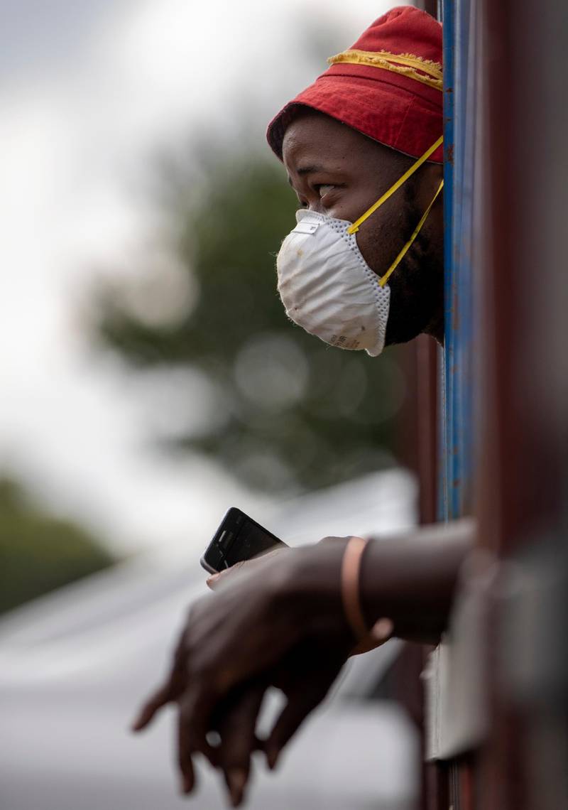 A man wearing a face mask to protect against coronavirus, watches the South African National Defence Forces raids a hostel in densely populated Alexandra township east of Johannesburg, South Africa. AP Photo