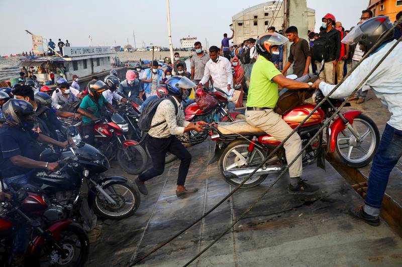 People on motorcycles rush to board a ferry at Mawa Ferry Terminal to get home to celebrate Eid al-Fitr, after the government imposed coronavirus disease restrictions on long-route public transport, in Munshiganj, Bangladesh. Reuters