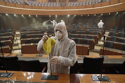 TOPSHOT - Sanitary workers disinfect the desks and chairs of the Lebanese Parliament in central Beirut on March 10, 2020 amid the spread of coronavirus in the country.  / AFP / ANWAR AMRO
