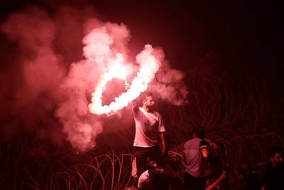 An anti-government protester waves a flare during a street demonstration. AP Photo
