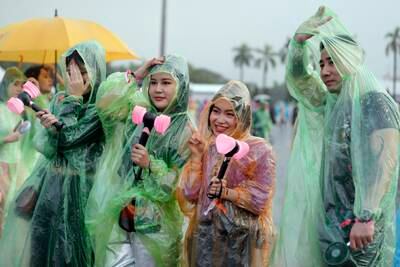 Fans of the K-pop band Blackpink wear colorful rain covers as they wait in the rain for a concert at the My Dinh National Stadium in Hanoi, Vietnam. EPA