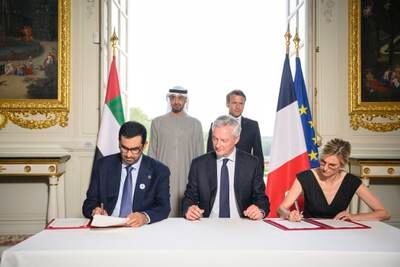 Sheikh Mohamed and Mr Macron watch as Dr Sultan Al Jaber, UAE Minister of Industry and Advanced Technology, and managing director and group chief executive of Adnoc, and France's Energy Transition Minister Agnes Pannier-Runacher sign a comprehensive strategic energy partnership between the two countries. Photo: Presidential Court