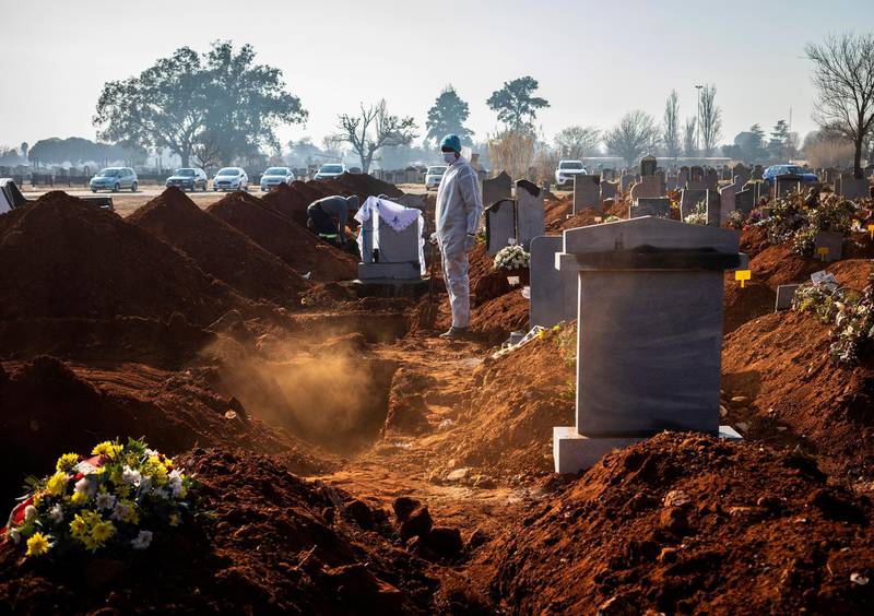 A family member wearing a full PPE suite looks on after the funeral of a beloved elderly family member who died as a result of the elderly Covid-19 Coronavirus at a graveyard on the 119 day of lockdown due to the Covid-19 Coronavirus, Johannesburg, South Africa, 24 July 2020.  EPA