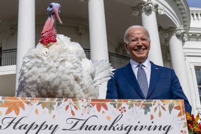 US President Joe Biden stands next to Liberty, one of the two national Thanksgiving turkeys, after pardoning them at a ceremony on the White House's South Lawn in Washington.  AP