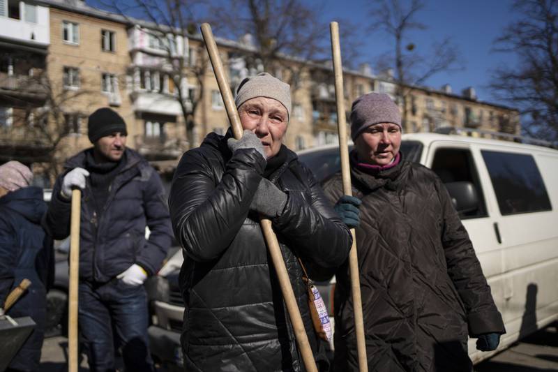 A woman cries before starting to clean the site where a bomb damaged residential buildings in Kyiv. AP Photo / Rodrigo Abd