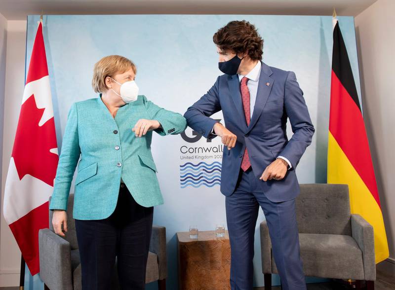 Canadian Prime Minister Justin Trudeau welcomes German Chancellor Angela Merkel at the start of a G7 bilateral meeting. AP