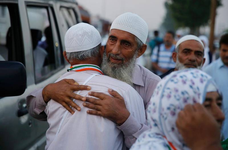 A Kashmiri man hugs his relative before beginning his Hajj pilgrimage.  EPA