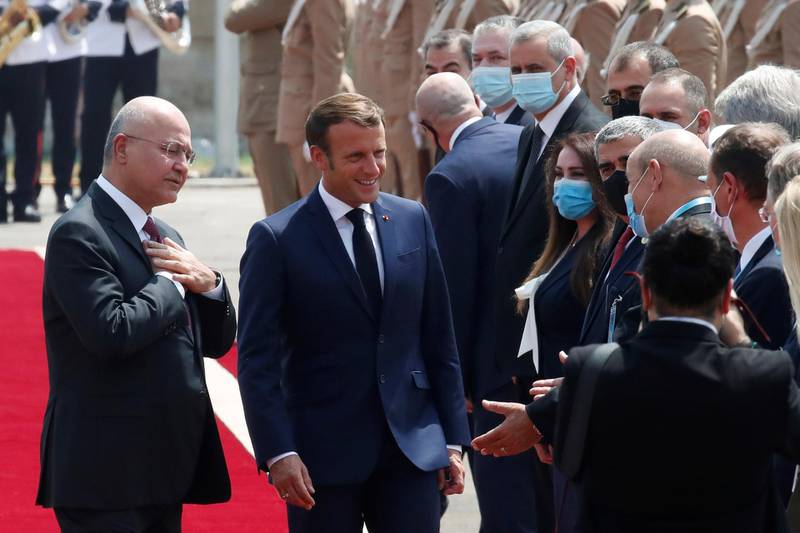 Iraqi President Barham Salih and France's Emmanuel Macron, centre, at the Salam Palace in Baghdad. AP