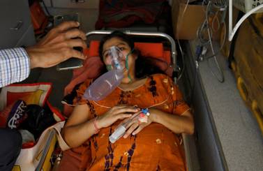 Madhuriben S Parmar reacts with an oxygen mask on as she speaks to her family on a video call while lying in an ambulance waiting to enter a COVID-19 hospital for treatment, amidst the spread of the coronavirus disease (COVID-19) in Ahmedabad, India, April 28, 2021. REUTERS/Amit Dave