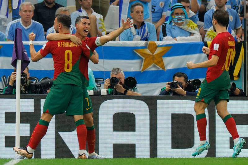 Portugal's Cristiano Ronaldo celebrates with teammates Bruno Fernandes and Bernardo Silva, after Fernandes scored his team's first goal against Uruguay. AFP