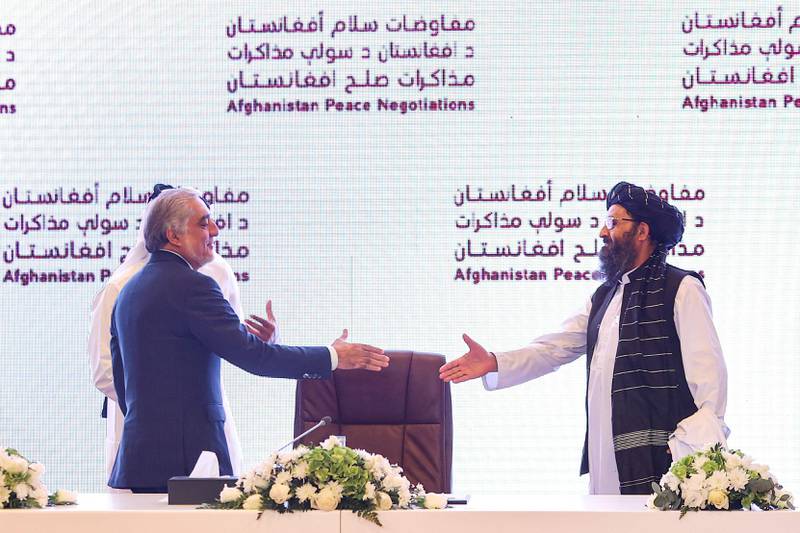 Abdullah Abdullah (L) shakes hands with the leader of the Taliban negotiating team, Mullah Abdul Ghani Baradar, in Doha. AFP