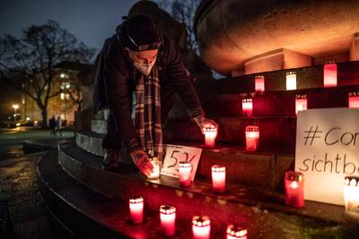 Christian Y. Schmidt picks up a candle at a makeshift memorial for Covid victims at Arnswalder Platz in Berlin, Germany. Getty Images