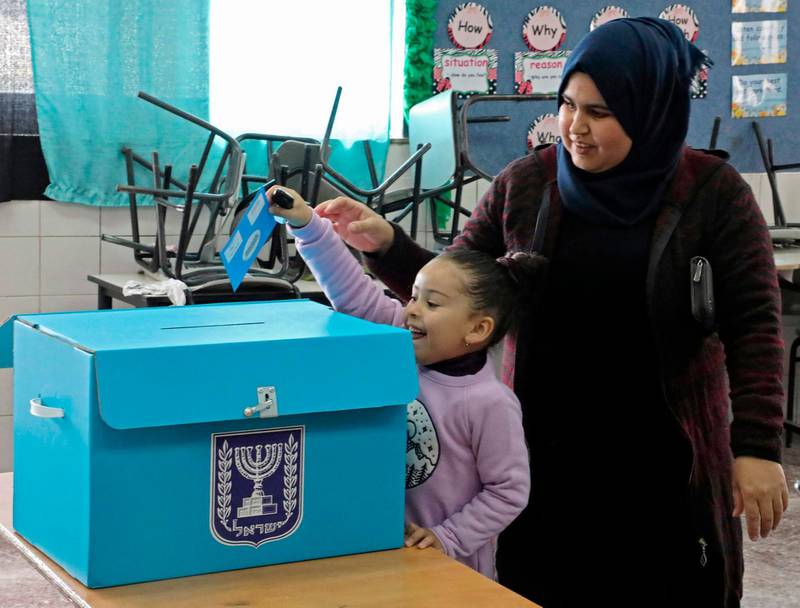 An Arab-Israeli girl casts her mother's ballot in the parliamentary election at a poling station in the Bedouin town of Rahat near the southern Israeli city of Beersheba on March 2, 2020. AFP