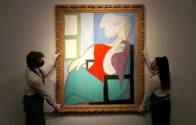 Employees pose for a photograph with "Femme Assise Pres d'Uune Fenetre (Marie-Therese)" by Pablo Picasso at Christie's gallery prior to the New York spring season of evening sales, in London, Britain, April 22, 2021. REUTERS/Peter Nicholls   NO RESALES. NO ARCHIVES.