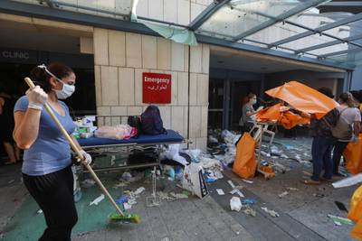 A woman sweeps at a damaged hospital following Tuesday's blast, in Beirut. Reuters