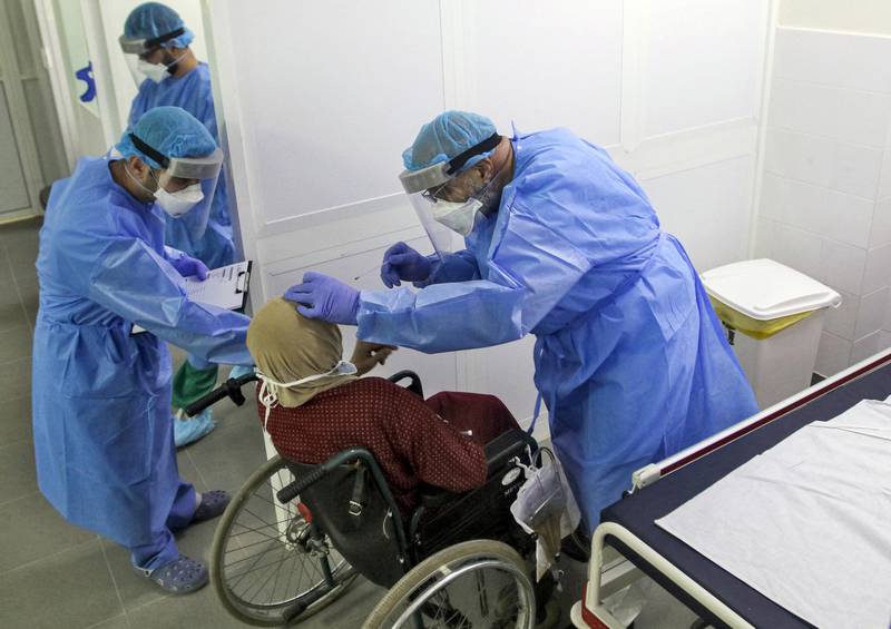 A doctor tests a woman at a hospital, as part of a mobile clinic initiative by LAU (Lebanese American University) School of Medicine and LAU Medical Center-Rizk Hospital to provide medical services to remote areas, in the southern Lebanese city of Nabatieh on April 4, 2020. (Photo by Mahmoud ZAYYAT / AFP)