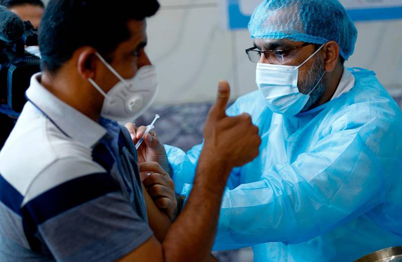 An Iraqi medic administers a shot of the Sinopharm coronavirus vaccine to a man giving a thumbs up, during vaccination of health personnel, at a clinic in Baghdad. AP Photo