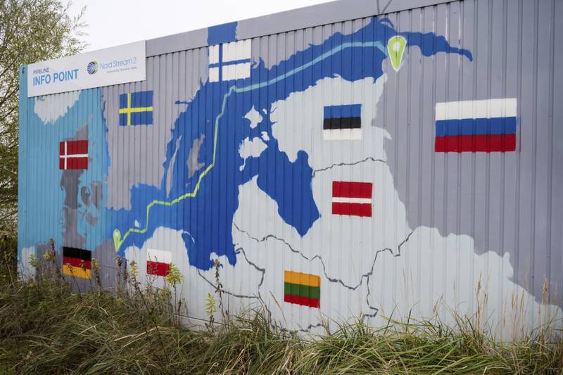 A sign reading 'Nord Stream 2, committed, reliable, safe' hangs above a painted map at the natural gas receiving station in the Lubmin industrial estate in Lubmin, Germany. AP Photo