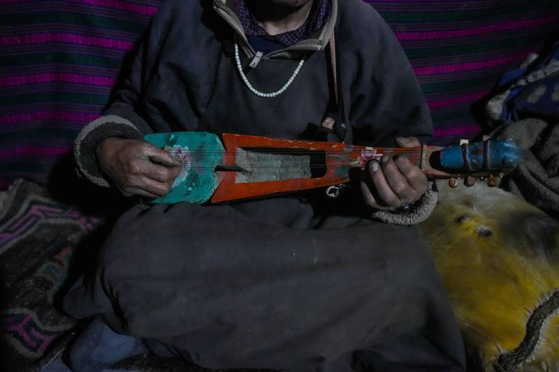 Nomad Tsering Choldan plays a traditional music instrument inside his mud house.