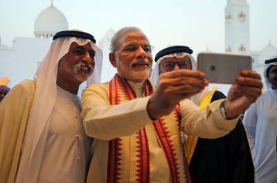 Indian Prime Minister Narendra Modi, middle, takes a selfie next to Sheikh Hamdan bin Mubarak Al Nahyan, UAE Minister of Higher Education and Scientific Research, left, as they tour the Sheikh Zayed Grand Mosque during the first day of his two-day visit to the UAE, in Abu Dhabi, United Arab Emirates, Sunday, Aug. 16, 2015.  The UAE is home to over two million Indian expatriates and this is the first visit by an Indian premier in over three decades. (AP Photo/Kamran Jebreili)