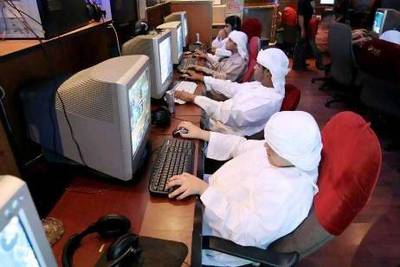 Young boys surf the web at an internet cafe in Abu Dhabi.