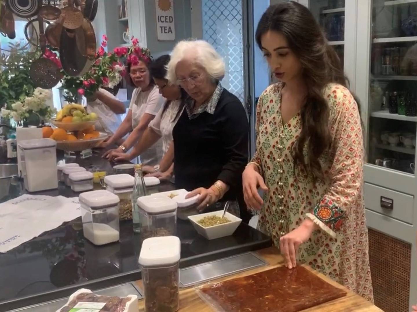 Ingredients are set out for the annual preparation of kleicha, or traditional Iraqi date cookies, by Dr Reem's daughter, Mae-Nouf, next to her grandmother, Buthaina Al Kadhi, Cristeta 'Dalia' Ardenio, and the El Mutwalli family's long-time housekeeper, Aida Roncales Tenedero.  Photo: Dr Reem El Mutwalli