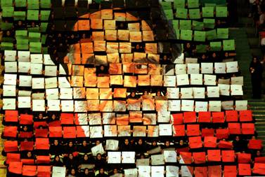 Girls in black uniforms hold up an image mosaic of Ayatollah Khomeini made up of individual boards in Azadi Stadium, Tehran, in 1999. Getty Images