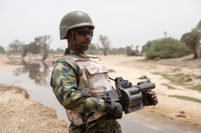 A Nigerian soldier, with a grenade launcher, stands guard near the Yobe river, that separates Nigeria from Niger, on the outskirt of the town of Damasak in North East Nigeria on April, 25 2017 as thousands of Nigerians, who were freed in 2016 by the Nigerian army from Boko Haram insurgents, are returning to their homes in Damasak. - Yagana Bukar's younger brothers Mohammed and Sadiq were among about 300 children kidnapped by Boko Haram from the town of Damasak in remote northeastern Nigeria nearly three years ago. But instead of the global outrage and social media campaign that followed a similar abduction of 219 schoolgirls from the town of Chibok, there were no protests for the children of Damasak. (Photo by Florian PLAUCHEUR / AFP)