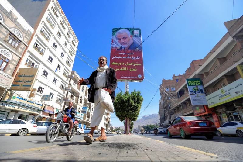 A Yemeni man walks beneath a poster of assassinated Iranian military commander Qassem Suleimani in the capital Sanaa. AFP