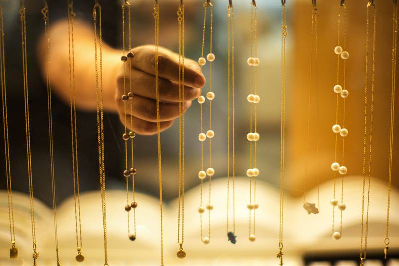 A seller puts pearl collars on display in his shop in Souq Waqif market, Doha, Qatar. AP Photo