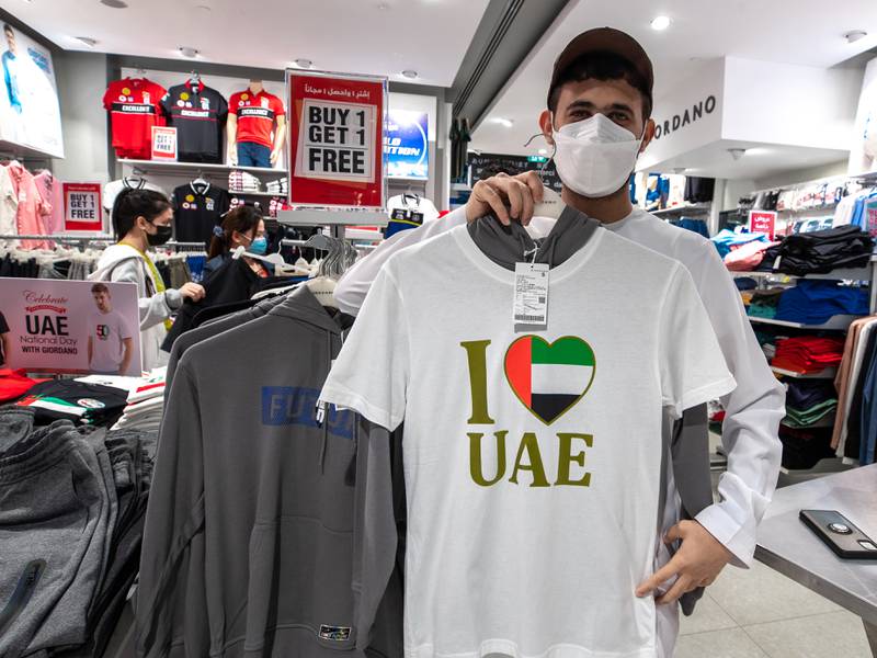 Ameer Al Ameri with a National Day T-shirt at the Giordano shop in Al Wahda Mall. Victor Besa / The National