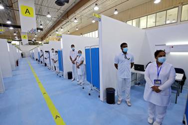 (FILES) In this file photo taken on December 23, 2020 Medical staff stand ready at the Kuwait vaccination center for COVID-19 at the International Fairgrounds in Kuwait City. Sports stadiums, cathedrals and theme parks the world over have been rapidly repurposed as temporary vaccination centres in a global drive to administer the life-saving jabs. / AFP / YASSER AL-ZAYYAT