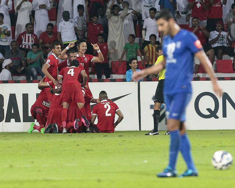 Al Ahli players celebrate the winning goal in injury time as the Dubai club gets past Al Hilal on Wednesday night in Dubai and advances to the Asian Champions League final. Jeffrey E Biteng / The National