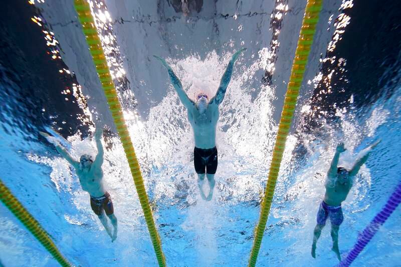 Britain's Adam Peaty, centre, swims to win the gold medal in the 100-metre breaststroke final.